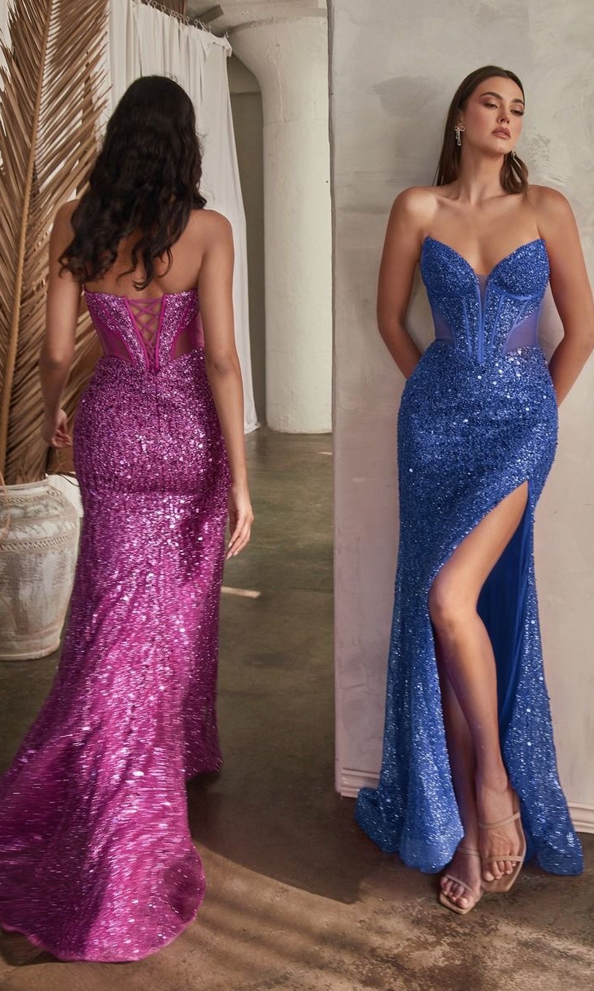 Two women stand indoors on a polished concrete floor, each wearing the Ladivine CD0227 Strapless Long Sequin Prom Dress—one in magenta with a sheer back, the other in blue with a thigh-high slit.